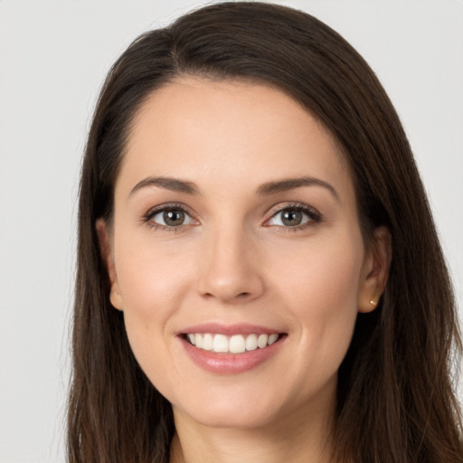 Joyful white young-adult female with long  brown hair and brown eyes