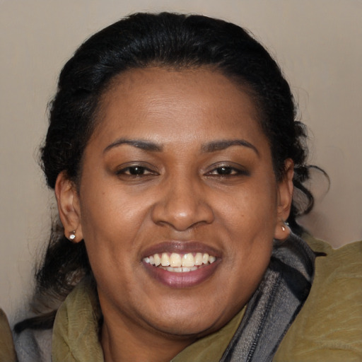 Joyful black adult female with long  brown hair and brown eyes
