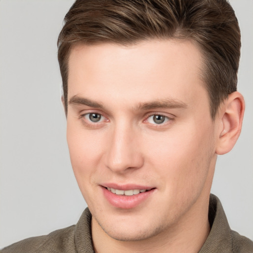 Joyful white young-adult male with short  brown hair and grey eyes