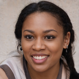 Joyful black young-adult female with long  brown hair and brown eyes