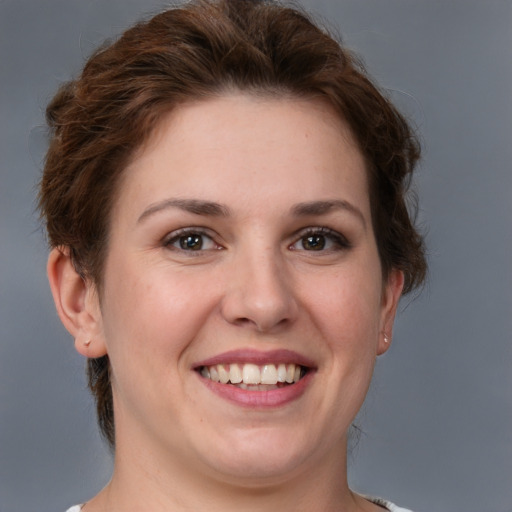 Joyful white young-adult female with short  brown hair and grey eyes