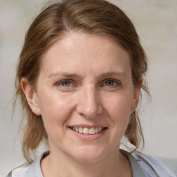 Joyful white adult female with medium  brown hair and blue eyes