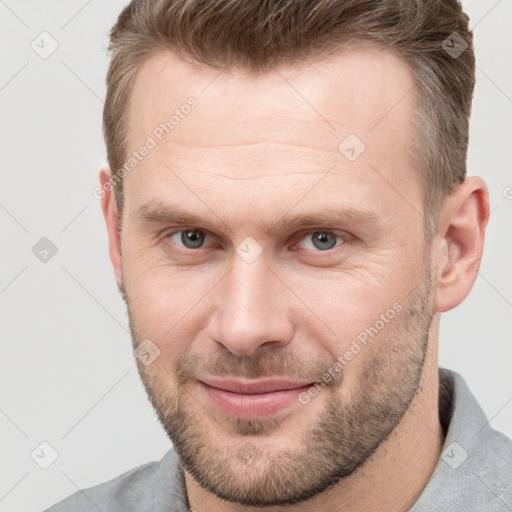 Joyful white adult male with short  brown hair and grey eyes