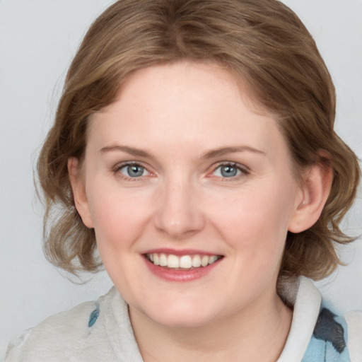 Joyful white young-adult female with medium  brown hair and blue eyes