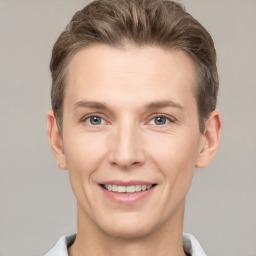 Joyful white young-adult male with short  brown hair and grey eyes