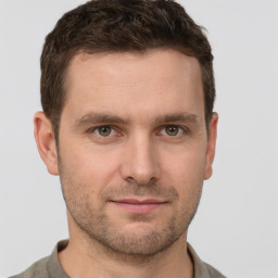 Joyful white young-adult male with short  brown hair and grey eyes