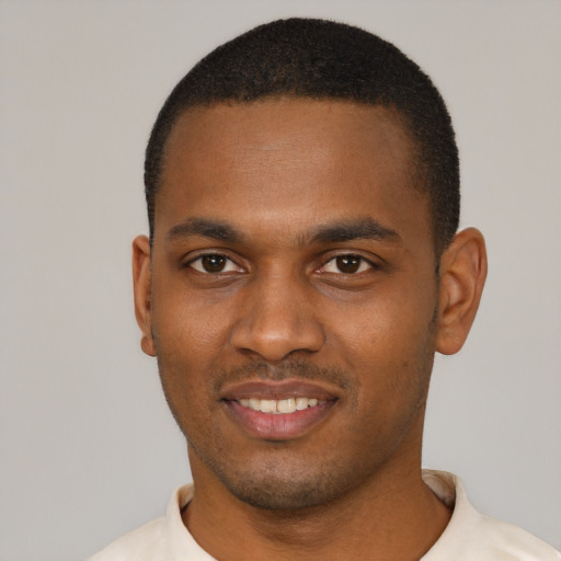 Joyful black young-adult male with short  black hair and brown eyes