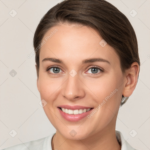 Joyful white young-adult female with short  brown hair and grey eyes