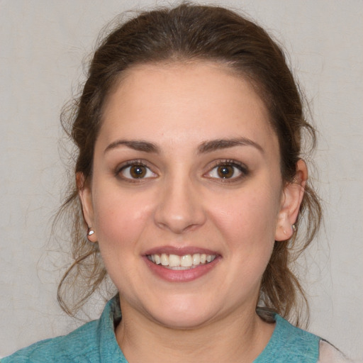 Joyful white young-adult female with medium  brown hair and grey eyes