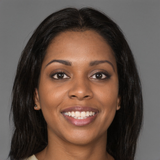 Joyful black young-adult female with long  brown hair and brown eyes