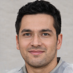 Joyful white young-adult male with short  black hair and brown eyes