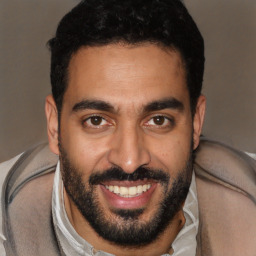 Joyful latino young-adult male with short  black hair and brown eyes