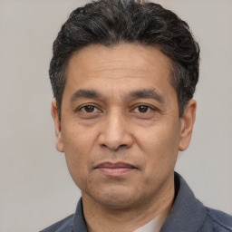 Joyful white adult male with short  black hair and brown eyes