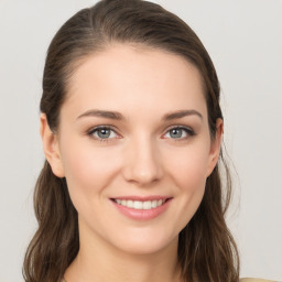 Joyful white young-adult female with long  brown hair and grey eyes