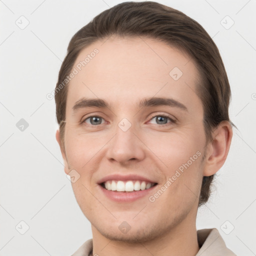 Joyful white young-adult male with short  brown hair and grey eyes