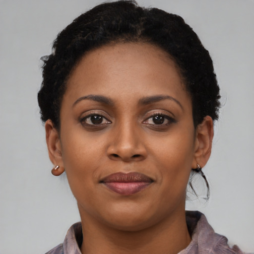 Joyful black young-adult female with short  brown hair and brown eyes