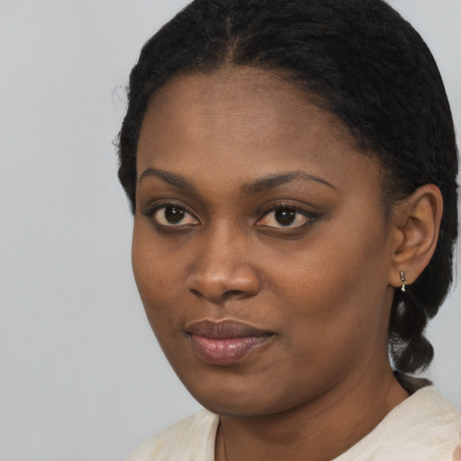 Joyful black young-adult female with long  black hair and brown eyes