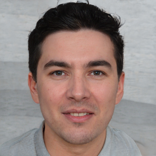 Joyful white young-adult male with short  black hair and brown eyes
