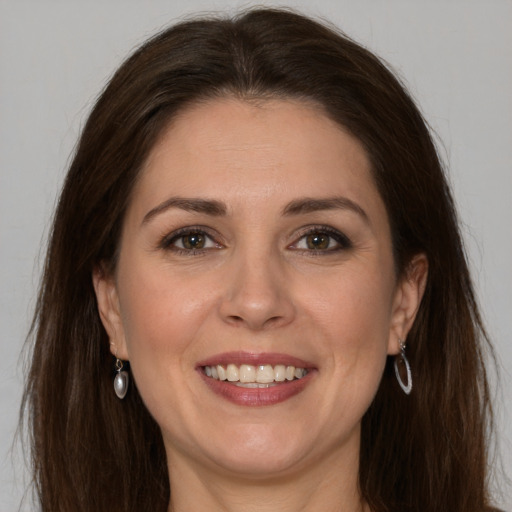 Joyful white adult female with long  brown hair and brown eyes