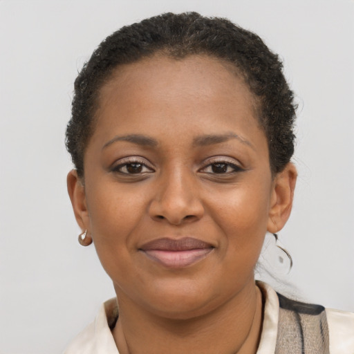 Joyful black young-adult female with short  brown hair and brown eyes