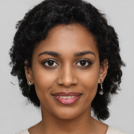 Joyful black young-adult female with long  black hair and brown eyes