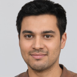 Joyful latino young-adult male with short  black hair and brown eyes