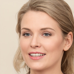 Joyful white young-adult female with long  brown hair and blue eyes