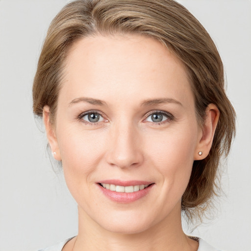 Joyful white young-adult female with medium  brown hair and blue eyes