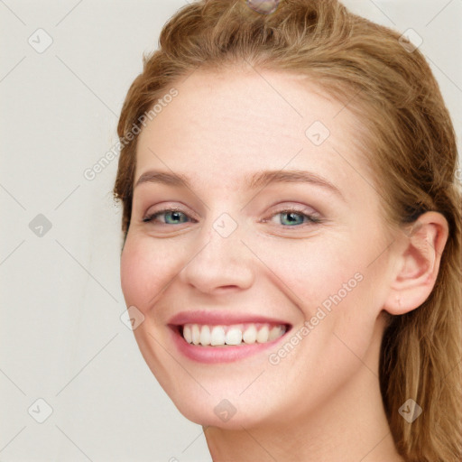 Joyful white young-adult female with long  brown hair and blue eyes