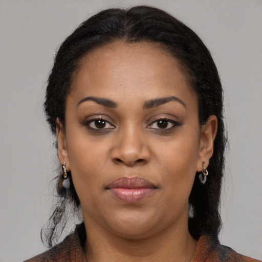 Joyful black young-adult female with long  black hair and brown eyes