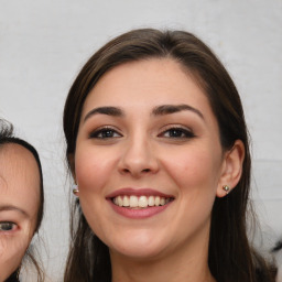 Joyful white young-adult female with long  brown hair and brown eyes