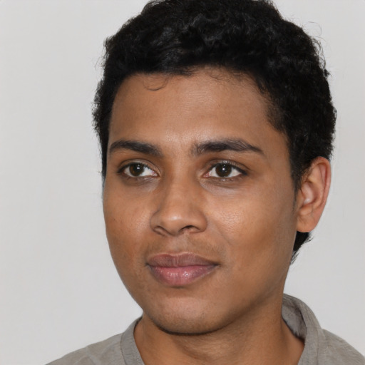 Joyful black young-adult male with short  black hair and brown eyes