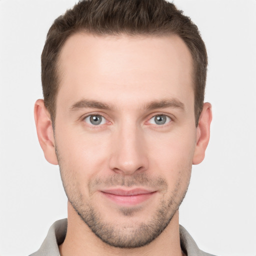 Joyful white young-adult male with short  brown hair and grey eyes