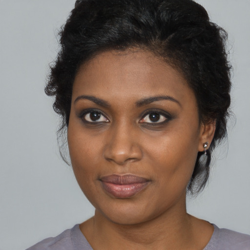 Joyful black young-adult female with medium  brown hair and brown eyes