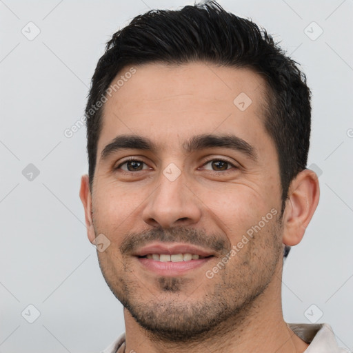 Joyful white young-adult male with short  black hair and brown eyes