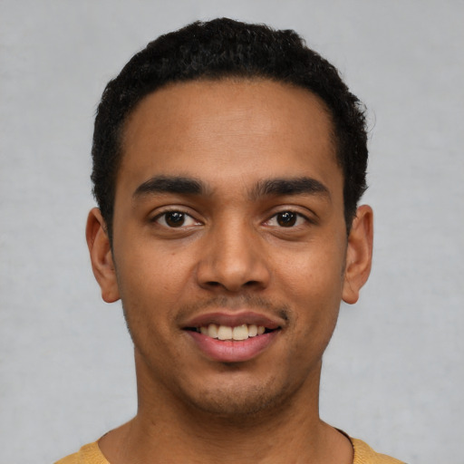 Joyful latino young-adult male with short  black hair and brown eyes