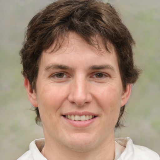 Joyful white young-adult female with short  brown hair and green eyes