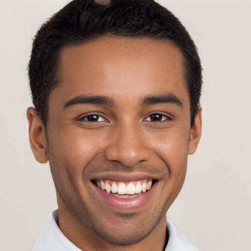 Joyful black young-adult male with short  black hair and brown eyes