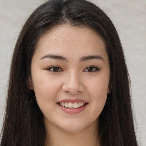 Joyful asian young-adult female with long  brown hair and brown eyes