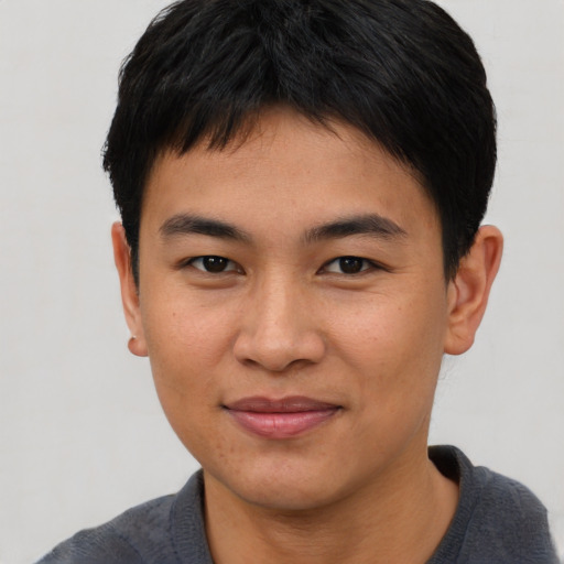 Joyful asian young-adult male with short  brown hair and brown eyes