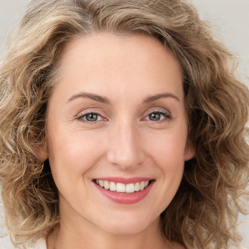 Joyful white young-adult female with medium  brown hair and green eyes