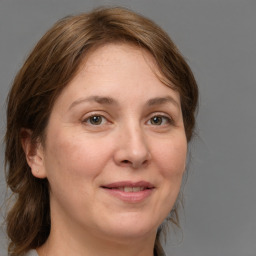 Joyful white adult female with medium  brown hair and grey eyes