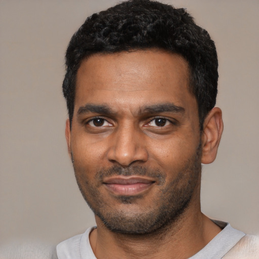 Joyful black young-adult male with short  black hair and brown eyes