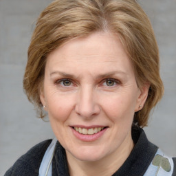 Joyful white adult female with medium  brown hair and blue eyes