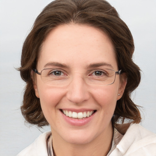 Joyful white adult female with medium  brown hair and grey eyes