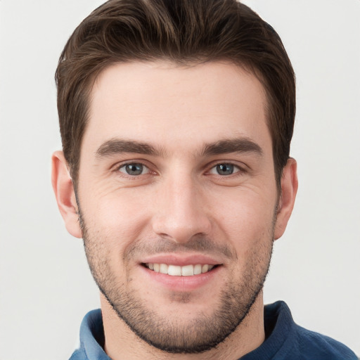 Joyful white young-adult male with short  brown hair and grey eyes