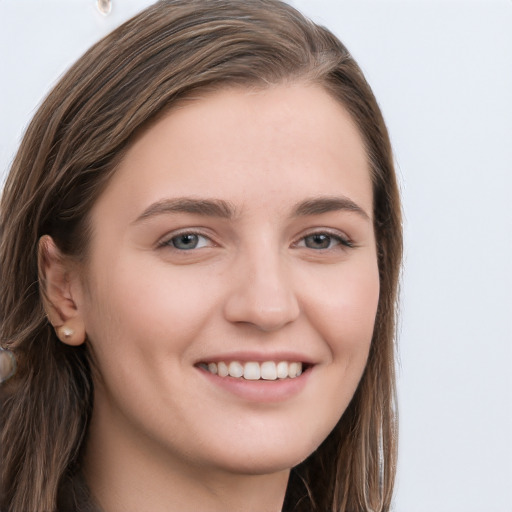 Joyful white young-adult female with long  brown hair and grey eyes