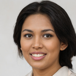 Joyful latino young-adult female with medium  brown hair and brown eyes