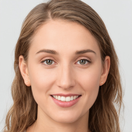 Joyful white young-adult female with long  brown hair and green eyes