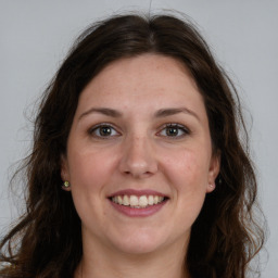 Joyful white adult female with long  brown hair and brown eyes